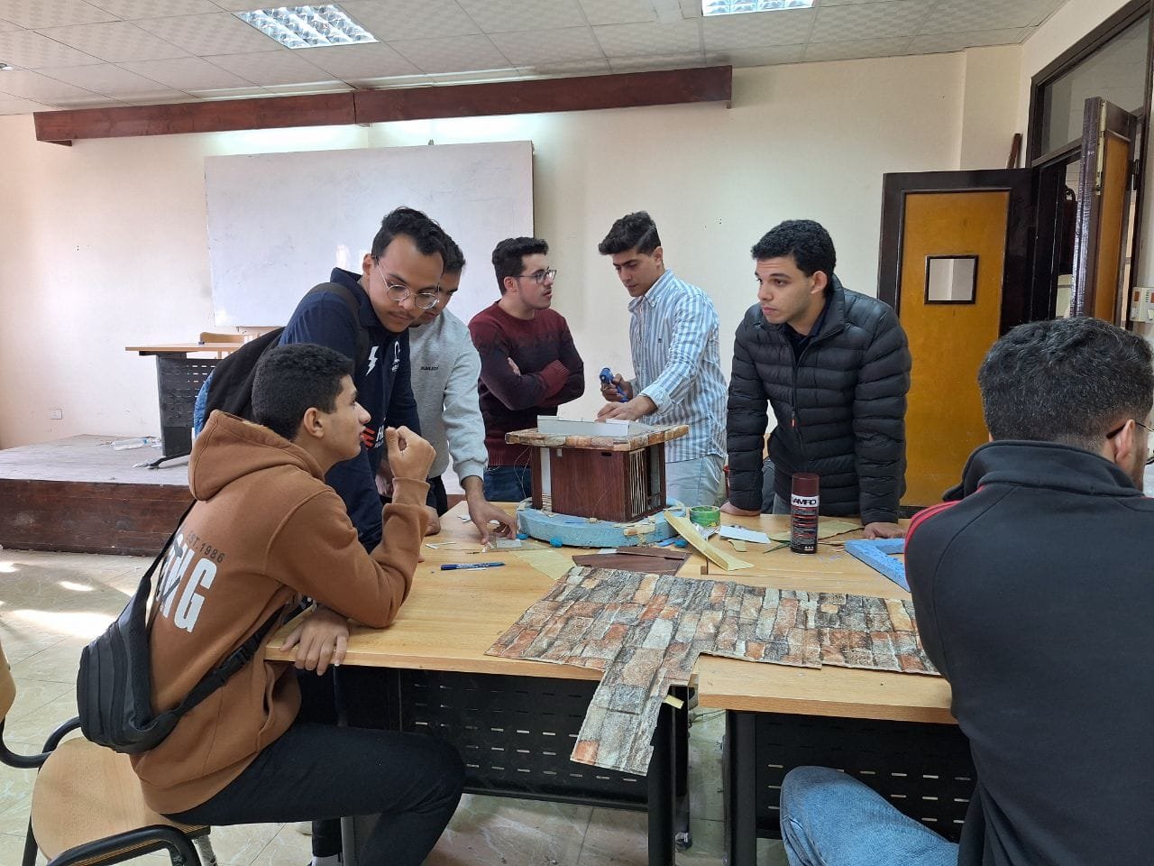 Students gathered around a workbench during a technical workshop